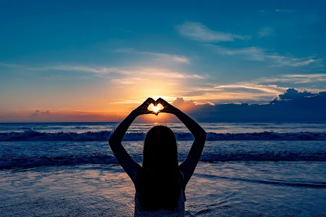 Frau mit Herz am Strand, Meer vor der Abendsonne